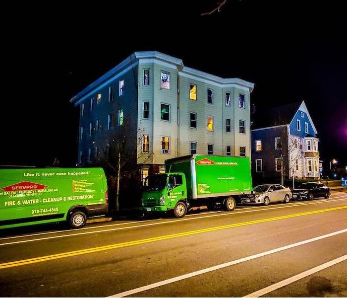 SERVPRO vehicles in front of an apartment building at night