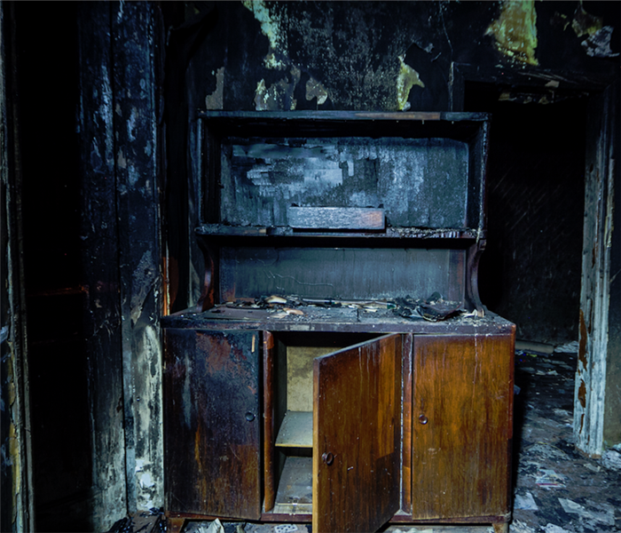 a fire damaged cabinet covered in soot